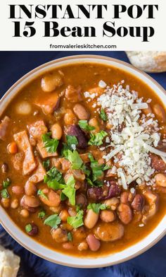 a white bowl filled with beans and parmesan cheese next to bread on a blue towel