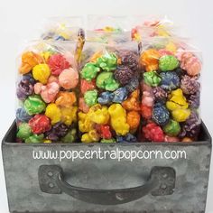 a metal box filled with lots of different colored gummy bear candies in plastic bags