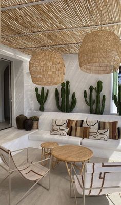 a living room filled with lots of furniture next to cactus plants and potted plants