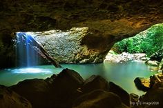 there is a small waterfall in the middle of this cave with water flowing from it