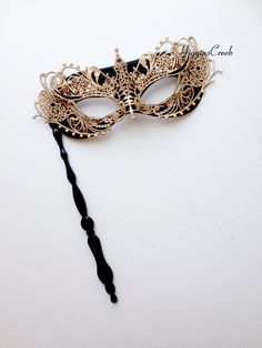 "Masquerade mask on a stick decorated with Gold lace overlay & Topaz/Crystal Rhinestones (more color available). The Mask comes attached to the stick. Perfect for any masquerade ball or costume party. Thank you for supporting small businesses and hope our products bring you and loved ones some joy and humor in these trying times. S H I P P I N G - Current processing times range 5-7 days. Pls note expedited & 1-2 day guaranteed delivery services offered will still require the same process Luxury Black Elegant Masks, Black And Gold Masquerade Mask Stick, Elegant Adjustable Masquerade Mask, Elegant Adjustable Masquerade Mask For Mardi Gras, Elegant Adjustable Masks For Party, Elegant Wedding Masquerade Mask Adjustable, Elegant Adjustable Masquerade Mask For Wedding, Elegant Adjustable Wedding Masquerade Mask, Elegant Adjustable Eye Mask