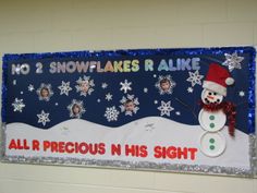 a bulletin board decorated with snowflakes and a snowman on it's side