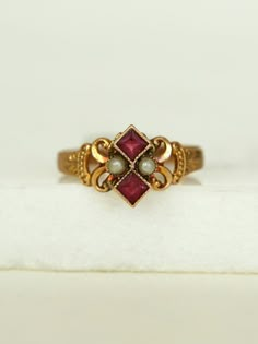 Her dainty Victorian style with gold work scrolls frame a powerful pair of Pearls and two stacked Rubies, set in a 10k gold band.  She's a fine addition to your collection.      	Ladies Size 6  	10k Yellow Gold Band  	Two Ruby red stones, pearls  	Arrives in gift box  Exclusively from Erin Pelicano Curated Vintage Collection. Each piece is intentionally chosen, pre owned, and ready to be loved and cherished again. sold as shown.  Shop the Curated Vintage Collection Dainty Vintage Jewelry, Victorian Rings Engagement, Pearl Jewelry Aesthetic, Gold Antique Ring, Victorian Wedding Ring, Vintage Gold Jewelry, Antique Ruby Ring, Unique Jewelry Vintage, Cute Promise Rings