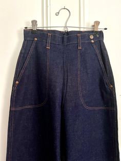 RARE Blue Bell (Wrangler Denim Co.) 1950s with Classic Side Zip! BRAND NEW Vintage Deadstock! Dark Denim w/ Orange stitching, 2 Front Pockets & 1 Back Pocket. Side Zip w 2 Snaps for Adjusting Waist. SIZE: Misses 12 (See Tag) These are "Misses" but might fit XXSmall Petite.  *Approximate* flat measurements: Waist flat across: 12"; Hips flat across: 18"; Leg opening: 8.5"; Inseam: 29"; Length: 43"  Denim History! Great for Vintage Store Display! Retro Dark Wash Bottoms With Pockets, Vintage Denim Blue Jeans With Pockets, Vintage High Rise Bottoms With Pockets, Vintage Dark Wash Bottoms With Patch Pockets, Vintage Denim Blue Bottoms With Pockets, Retro Blue Jeans With Patch Pockets, Vintage Blue Jeans With Patch Pockets, Vintage Pre-washed Blue Bottoms, Vintage High Rise Jeans With Patch Pockets