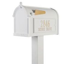 a white mailbox with gold lettering on it