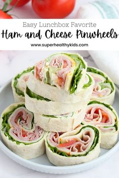 easy lunchbox favorite ham and cheese pinwheels on a plate with tomatoes in the background