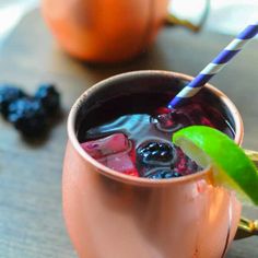 a drink in a copper mug with a blue and white striped straw garnish