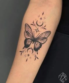 a black and white butterfly tattoo on the left arm with stars, moon and crescent