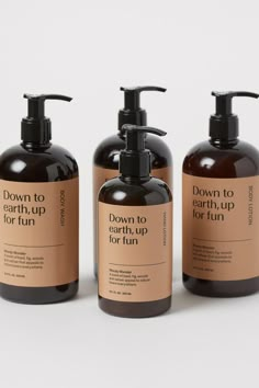 three bottles of soap and lotion on a white background with the words down to earth up for fun