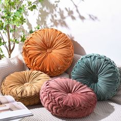 four different colored pillows sitting on top of a couch