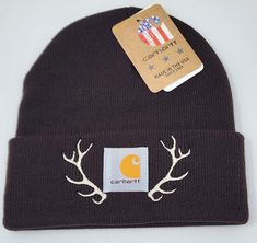 a beanie hat with antlers on it and a card attached to the front