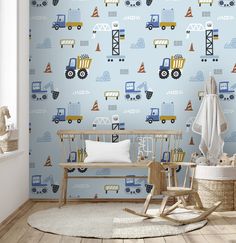 a child's room with blue wallpaper and construction vehicles on the wall next to a rocking chair