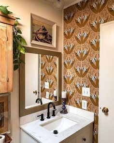 a bathroom sink sitting under a mirror next to a wall mounted faucet in front of a doorway