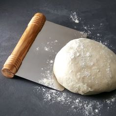 a ball of dough next to a rolling pin