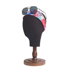 a hat with sunglasses on top of it sitting on a mannequin's head