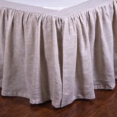 the bed skirt is made from linen and has ruffled edges