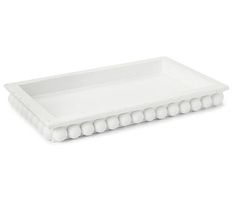 a white tray with balls on the bottom and an oval design in the middle, is shown