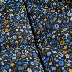 the blue and yellow flowered bedspread has many small flowers on it