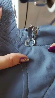 a woman is using a sewing machine to sew something on her leggings