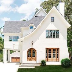 a large white house with wooden doors and windows