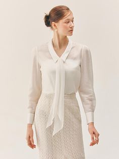 This product is a Laurel chiffon tie layered blouse that exudes a delicate and refined charm. The blouse features a soft tie at the neckline which can be styled in a bow for added femininity. The layering of chiffon gives the blouse a subtle translucence and fluidity, creating a sophisticated and versatile look suitable for both formal and casual occasions. - The chiffon tie at the neckline offers a graceful detail that enhances the blouse's elegant appeal.- Layered chiffon fabric provides a gentle, flowing silhouette and a hint of transparency.- Long sleeves culminate in neat cuffs, adding structure to the softness of the chiffon.- The blouse's design allows for versatile styling, making it a perfect pairing with both skirts and trousers for a range of looks. Elegant Fitted Chiffon Tops, Feminine Tie Neck Blouse With Bow, Elegant Tie Neck Blouse For Semi-formal Events, Elegant Tie Neck Blouse For Semi-formal Occasions, Elegant Semi-formal Tie Neck Blouse, Elegant Chiffon Top For Office Wear, Elegant Silk Tops With Bow Detail, Elegant Silk Tops With Bow, Elegant Silk Tie Neck Top