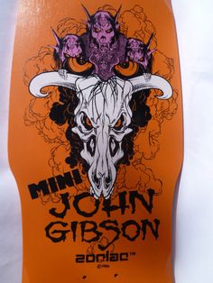 an orange skateboard with a skull and horns on it's front end is shown