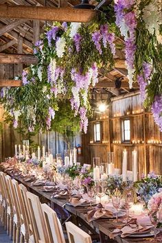 a long table with purple and white flowers hanging from it's centerpieces