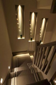 an overhead view of a staircase with lights on the wall and carpeted flooring