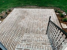 the stairs are made out of bricks and wrought iron railings that lead up to an open grassy area