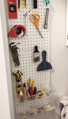 a peg board with tools hanging on it