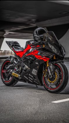 a red and black motorcycle parked in front of a building