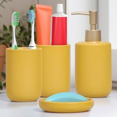 toothbrushes, soap dispenser and other bathroom accessories sit on a counter