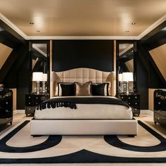 a bedroom with black and white decor, including a large bed in the middle of the room