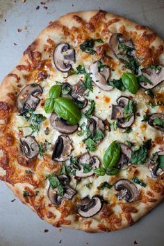 a pizza with mushrooms, garlic and spinach on it