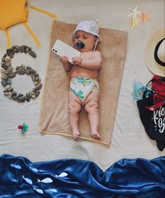 a baby laying on top of a blanket next to other items