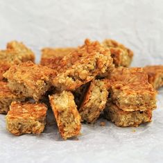 a pile of granola bars sitting on top of a piece of white parchment paper