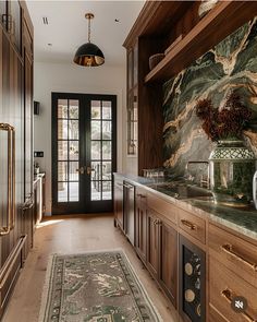 a large kitchen with marble counter tops and wooden cabinetry, along with an area rug on the floor