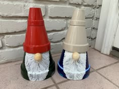 two ceramic gnomes sitting next to each other