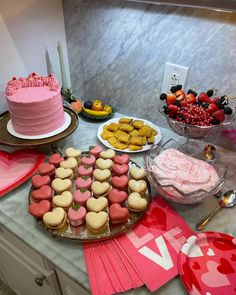 valentine's day dessert table with heart shaped cookies and cakes