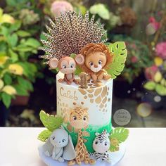 a cake decorated with animals and plants on a table