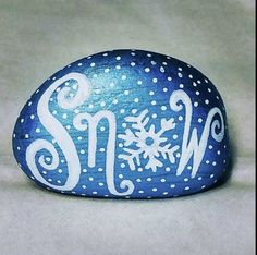 a painted rock with the word snow written in white on it's blue surface