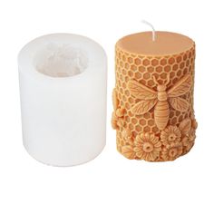 two bees and honeycombs are next to a candle