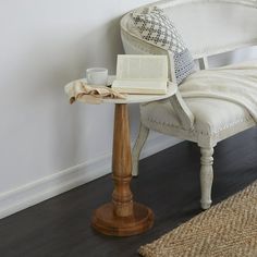 a white chair with a book and cup on it