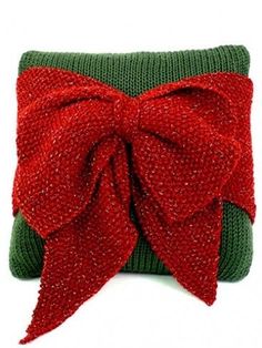 a green and red pillow with a bow on it