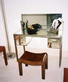 a desk with a chair and mirror on it