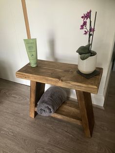 a wooden table with a towel on it next to a potted plant and a tube of toothpaste