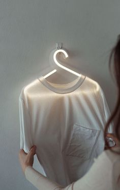 a woman looking at a t - shirt with the letter s on it's hanger