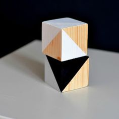 a wooden block sitting on top of a white table next to a black and white object