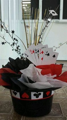 a black and red hat with playing cards in it sitting on the floor next to a window