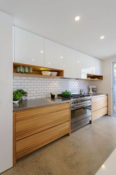 a kitchen with an oven, dishwasher and counter tops in white tiles on the walls